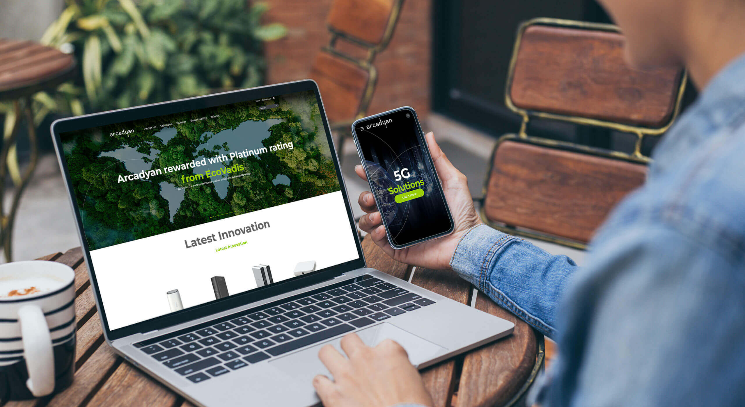 Person using redesigned Arcadyan website on laptop and smartphone